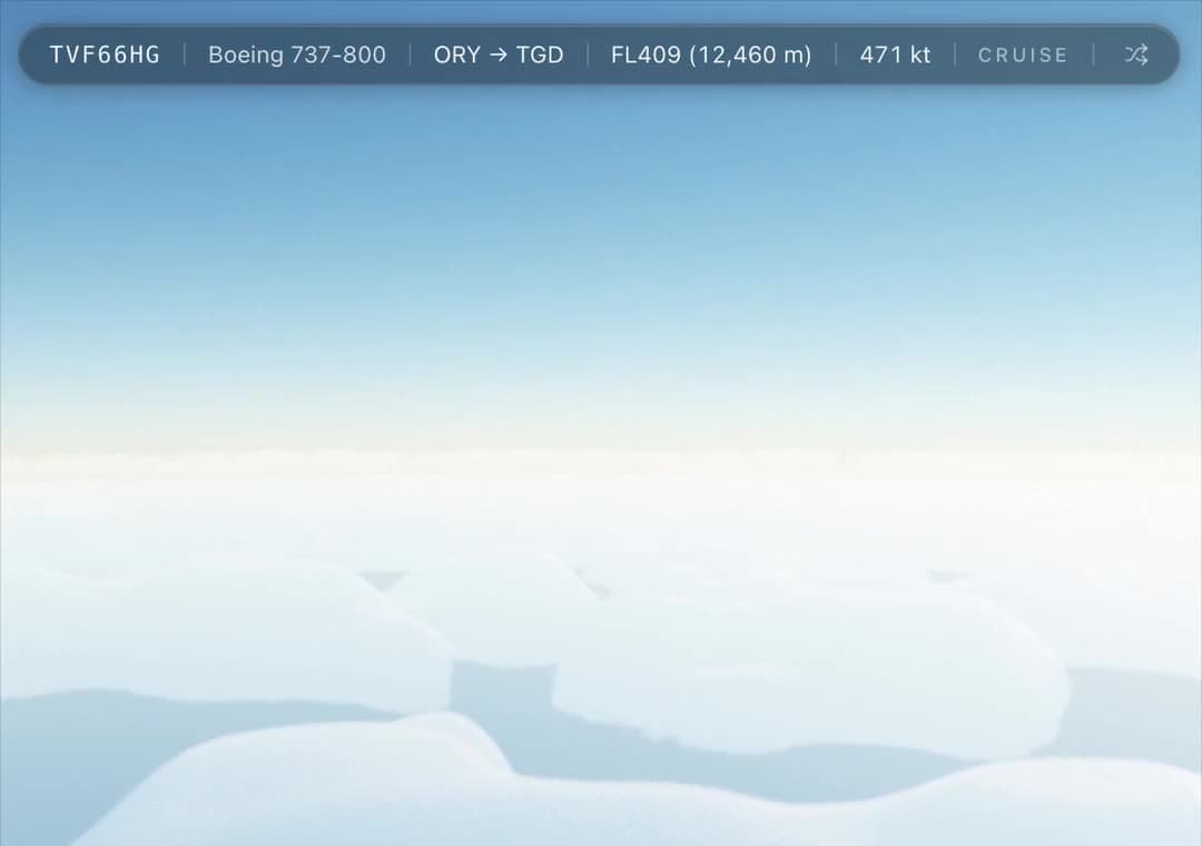 The Overwing view in flight: a heads-up strip reading TVF66HG, Boeing 737-800, ORY to TGD, FL409, 471 knots, cruise, above a deck of cloud.